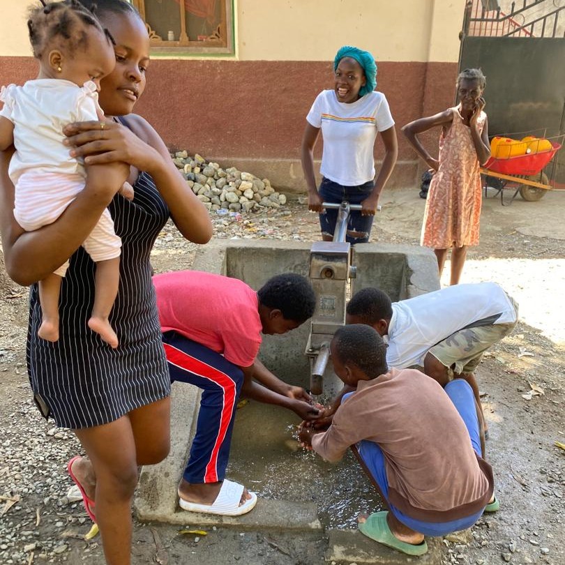 People around newly repaired pump